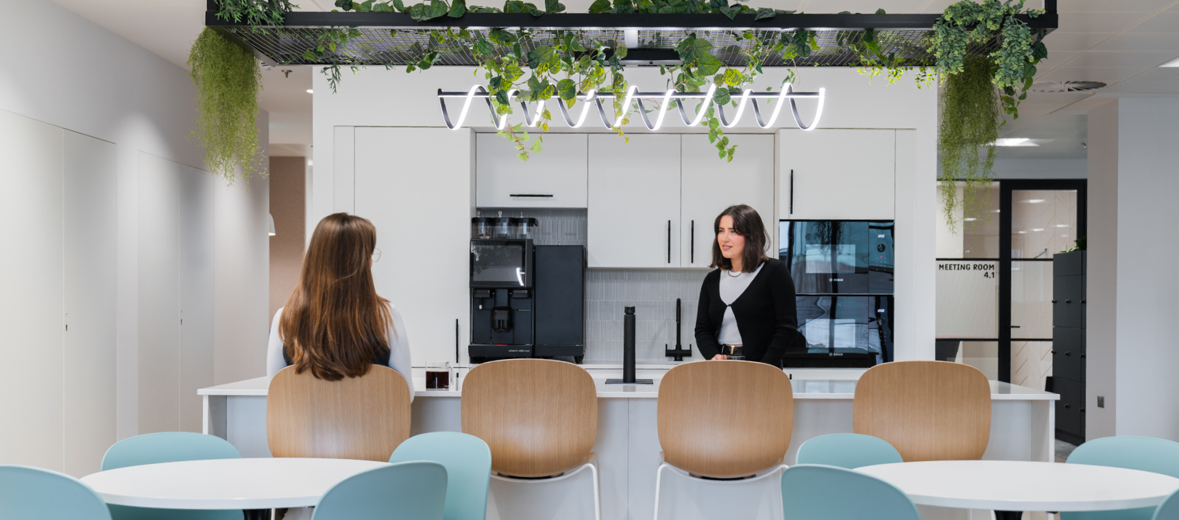 Two colleagues having a conversation over the kitchen island