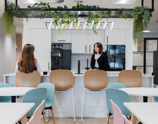 Two colleagues having a conversation over the kitchen island