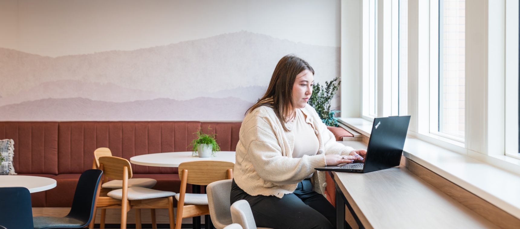 employee working on laptop in breakout space