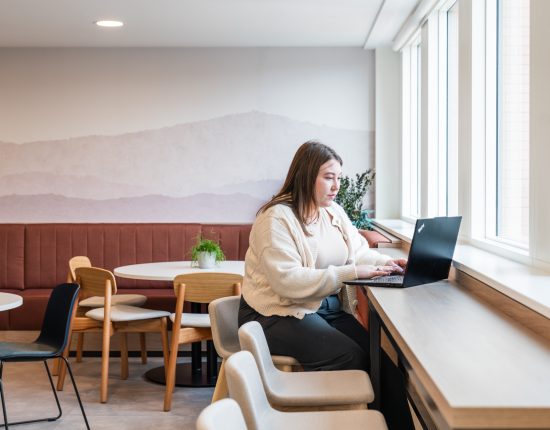 employee working on laptop in breakout space