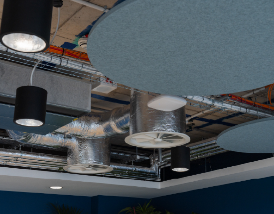An exposed ceiling with acoustic rafts