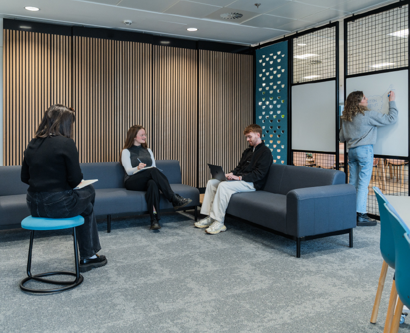 A collaboration space with lounge chairs, fidget stool and whiteboard movable walls