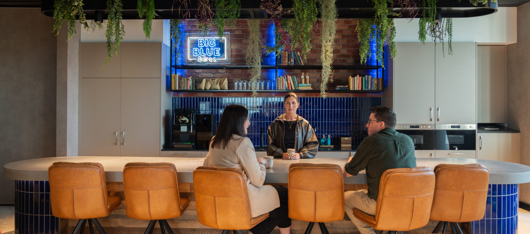 Co-workers enjoying a conversation over coffee in a canteen space