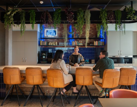 Co-workers enjoying a conversation over coffee in a canteen space